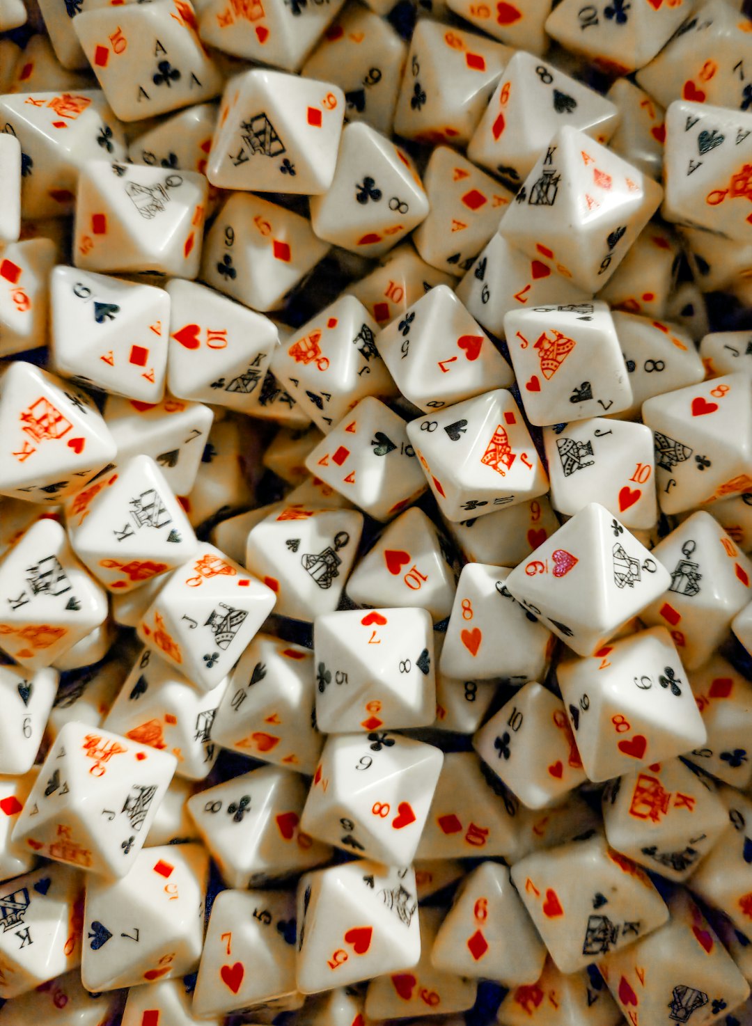 A pile of poker dice, commonly used in various gambling and casino games, stacked together in a casual, disorganized manner. The dice, with their distinct pips and vibrant colors, are essential for games like poker dice, adding an element of chance and excitement to the experience. This collection showcases the key role dice play in games of luck and strategy, making it a perfect representation of gambling culture and game night fun.